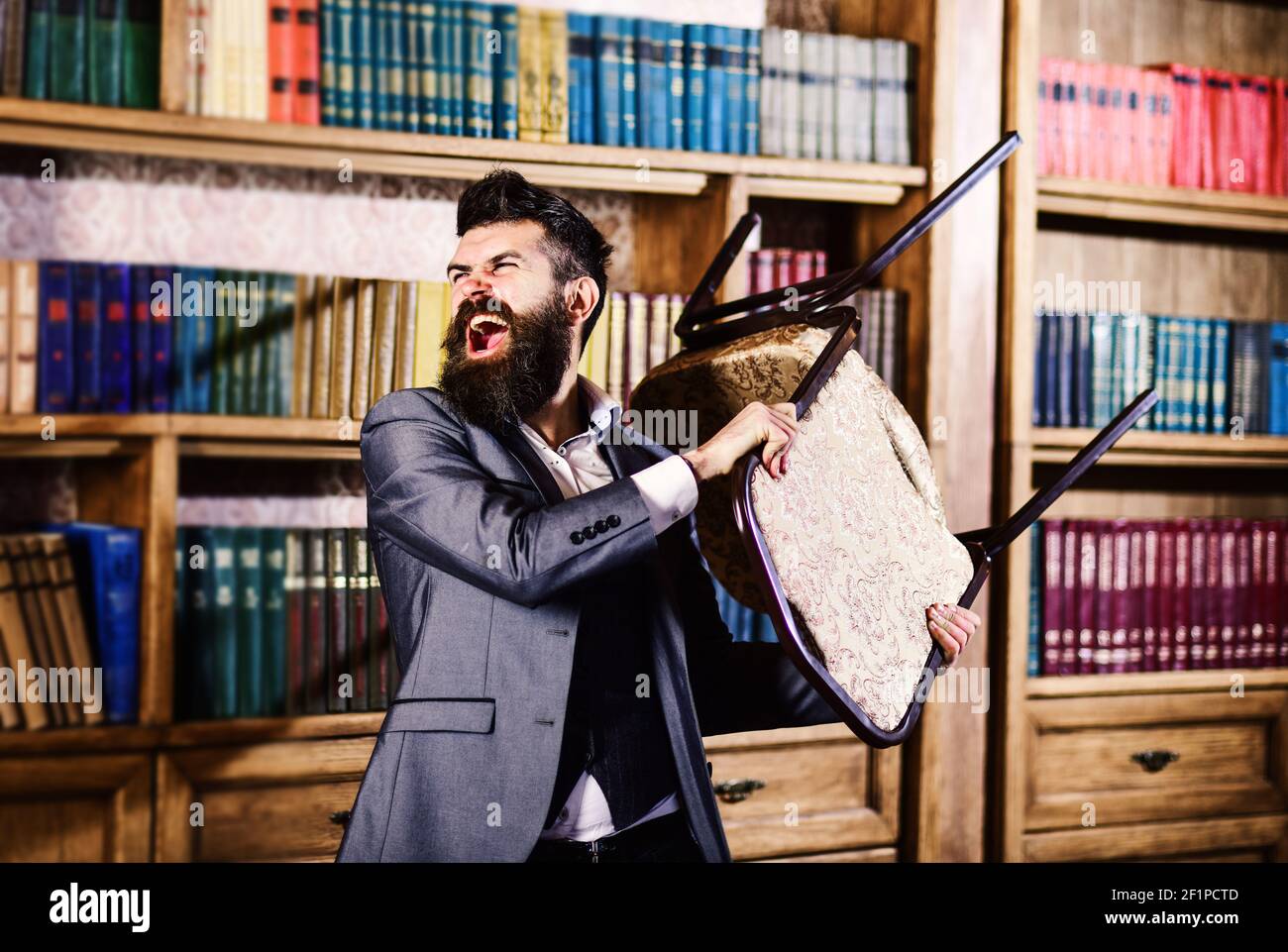 man throws a chair in vintage library Stock Photo Alamy