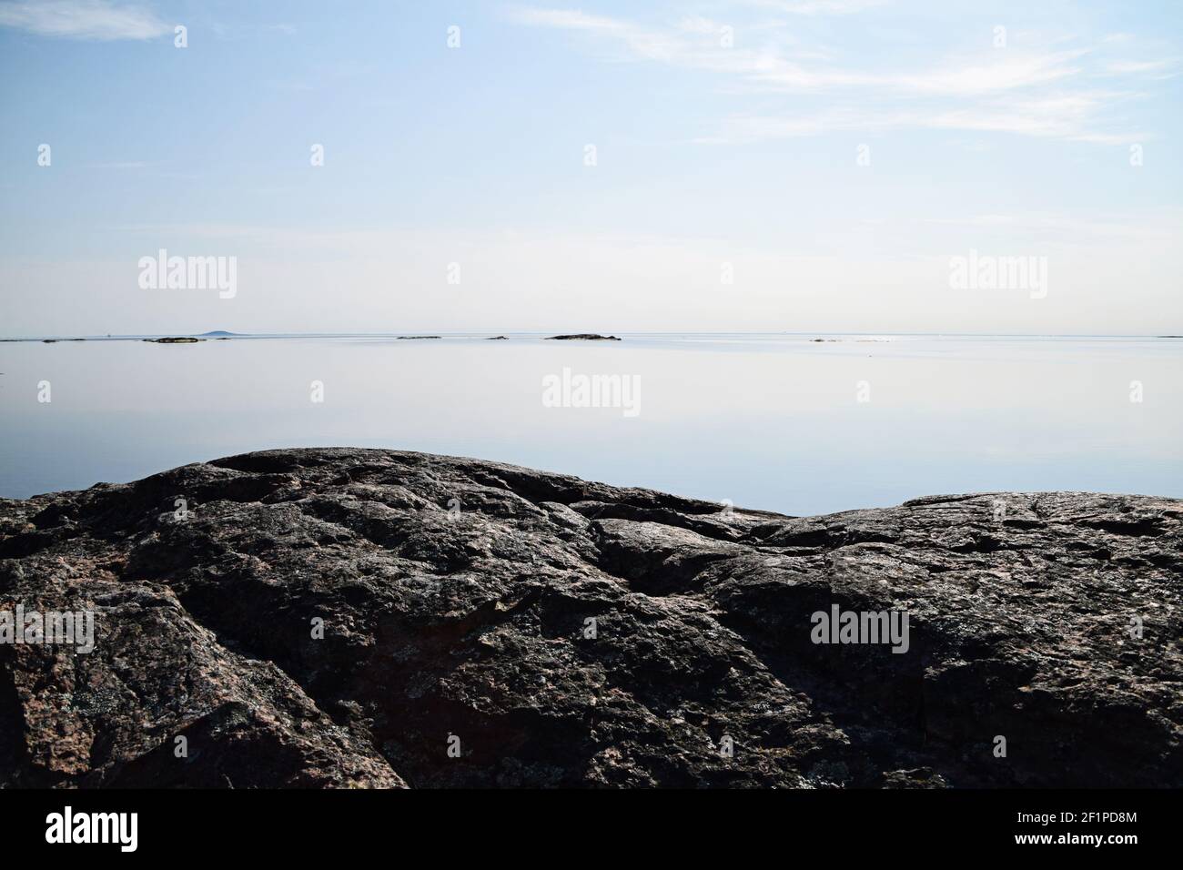 Calm water this sunny day in the archipelago. Focus on the foreground and the rock formation, typical for the Swedish archipelago nature. Stock Photo