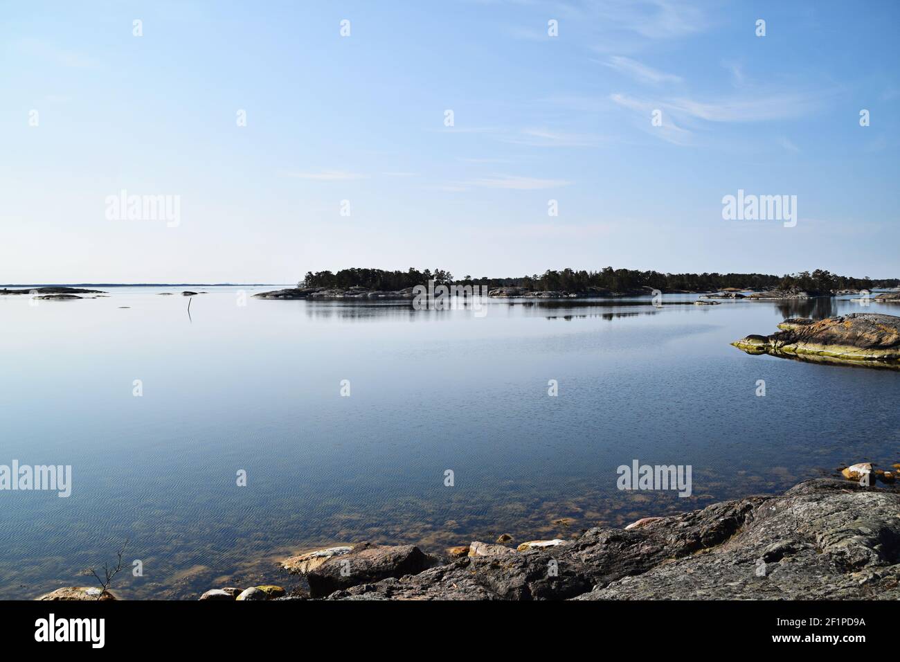 Tranquil sunny day in the Swedish archipelago. Calm water and no people around. Photo taken in the archipelago outside Oskarshamn in Sweden. Stock Photo