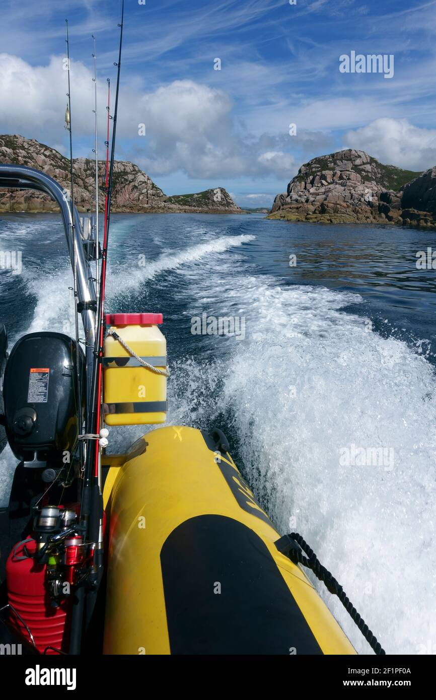 Rib with fishing rods heading out to sea through Tinkers Hole, Erraid, Isle of Mull, Scotland Stock Photo
