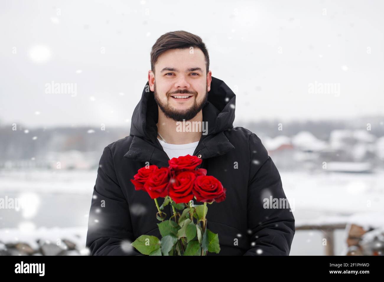 Handsome romantic young man with bouquet of red roses in hands Stock ...