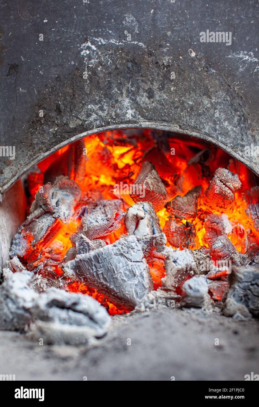 Burning coals in a metal grill for frying meat and vegetables. Cooking on a campfire. Stock Photo