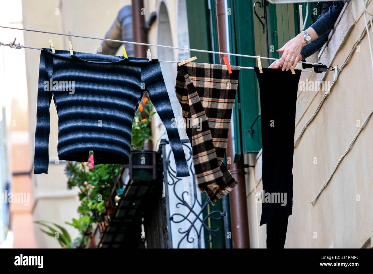 A closeup shot of a female hanging washed clothes on a rope Stock Photo