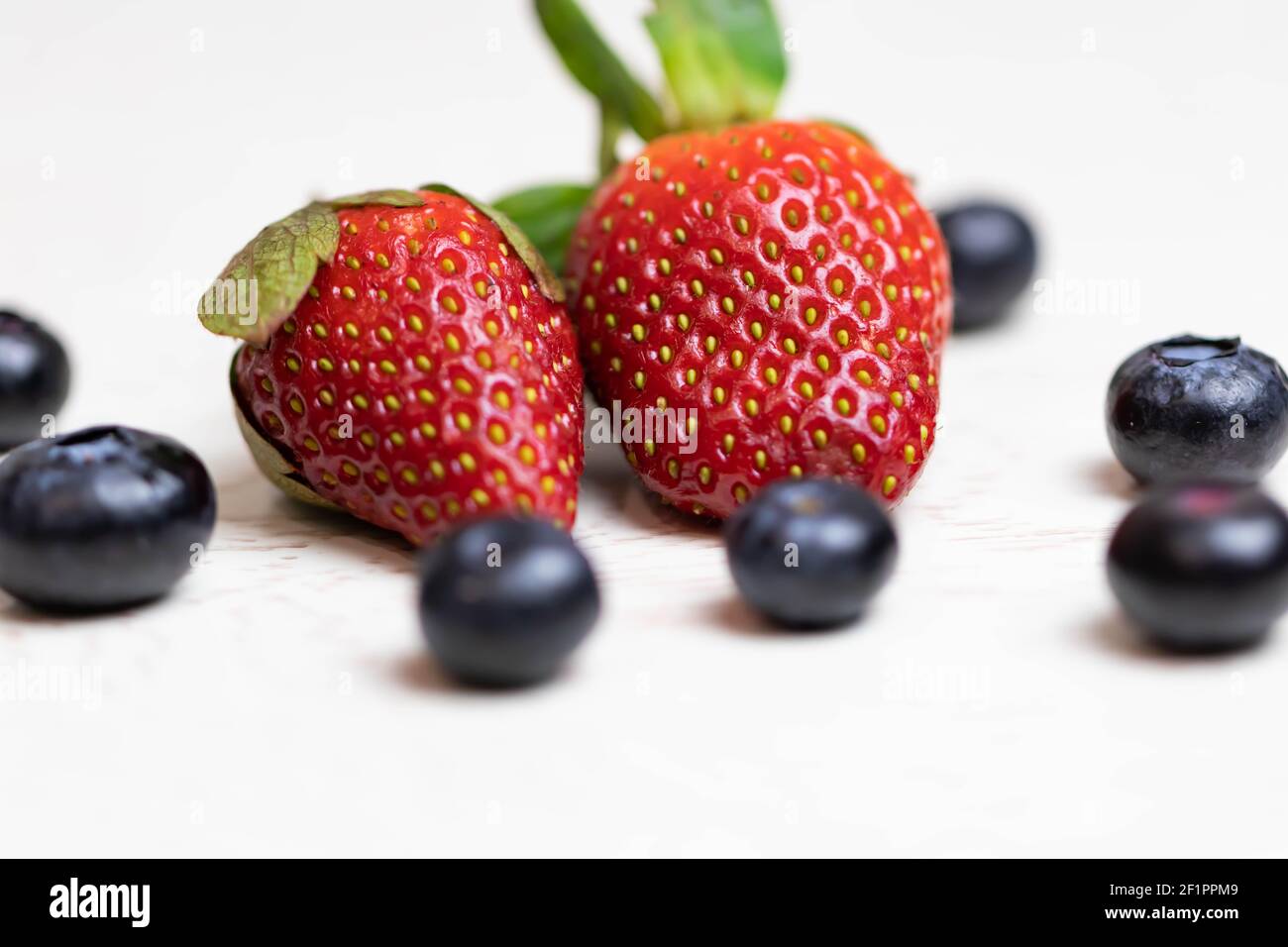 Ripe and juicy strawberries and blueberries on a white background ...