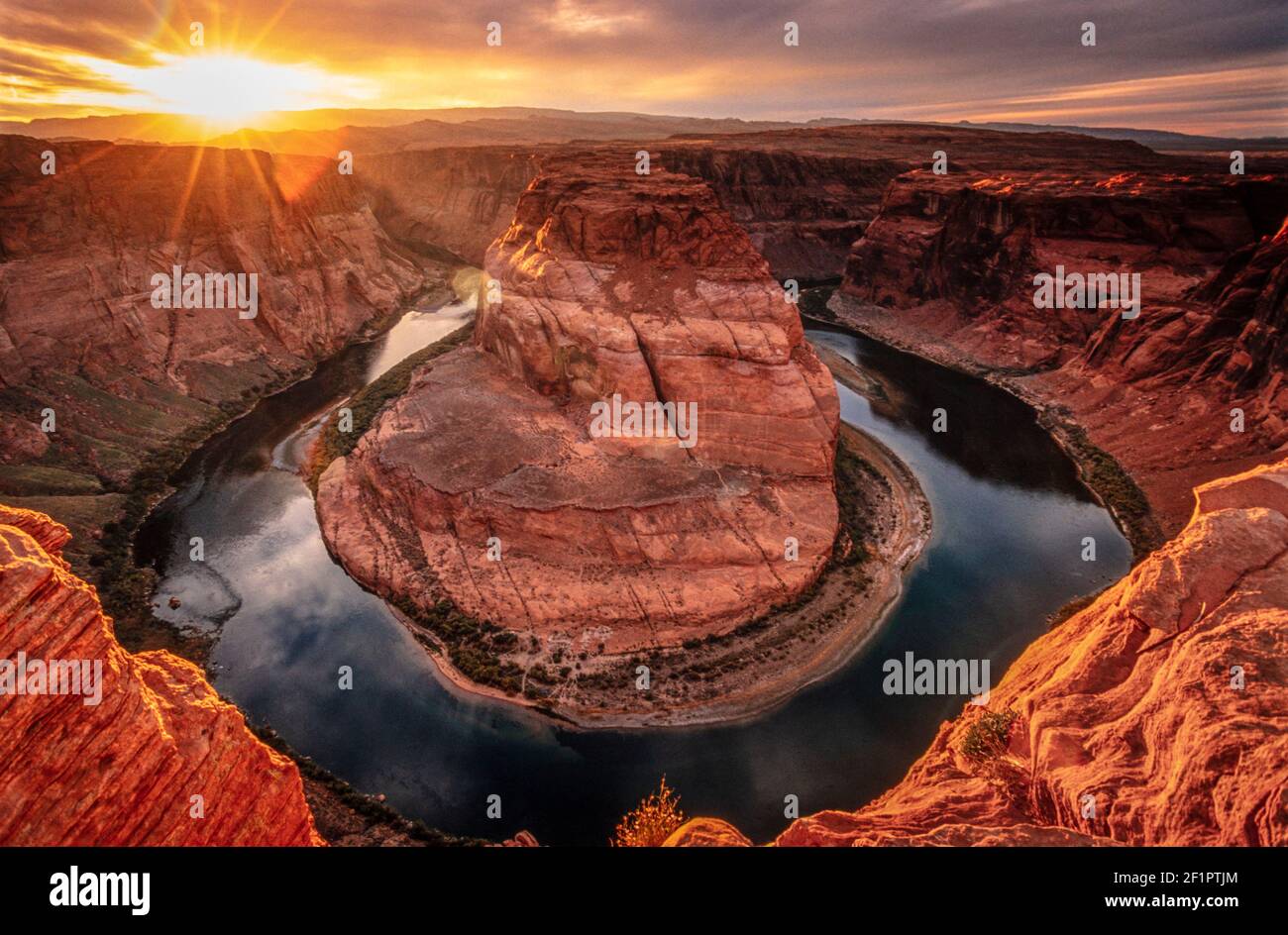 2002 Page Arizona Horseshoe bend - Sunset at Horseshoe bend on the colorado river at Page, Arizona, USA, four corners, United States of America, USA. Horseshoe Bend is a horseshoe-shaped incised meander of the Colorado River located near the town of Page, Arizona, United States. It is also referred to as the "east rim of the Grand Canyon." Horseshoe Bend can be viewed from the steep cliff above. Horseshoe Bend is an example of a entrenched meander.The overlook is 4,200 feet (1,300 m) above sea level, the Colorado River is at 3,200 feet (980 m) above sea level, making it a 1,000-foot drop Stock Photo