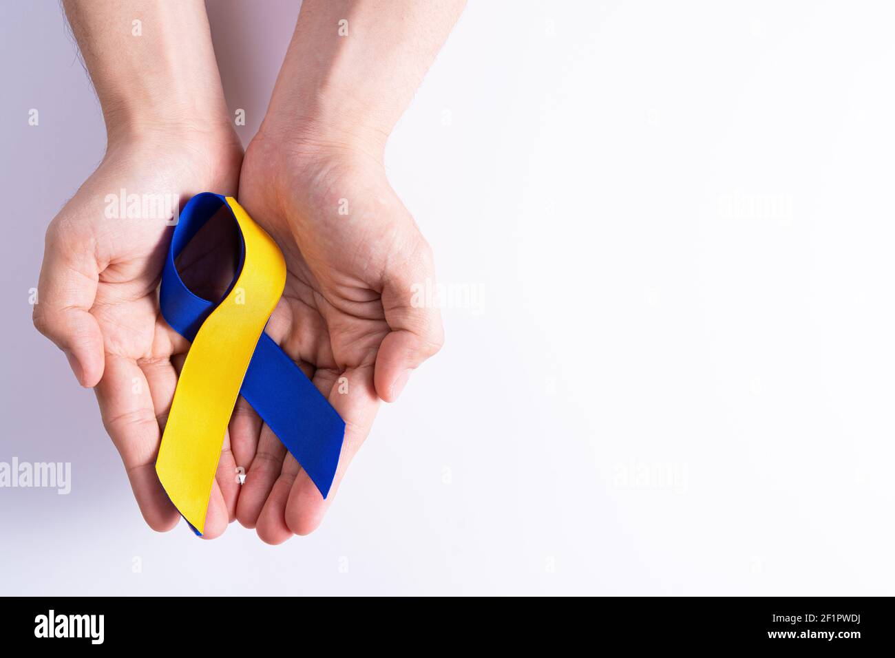 Down syndrome day, hands holding blue yellow ribbon awareness support ...
