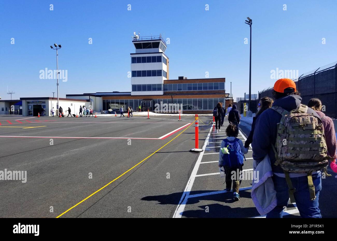New Castle, Delaware, U.S.A - February 14, 2021 - Passengers walking on the tarmac during a cold winter Stock Photo