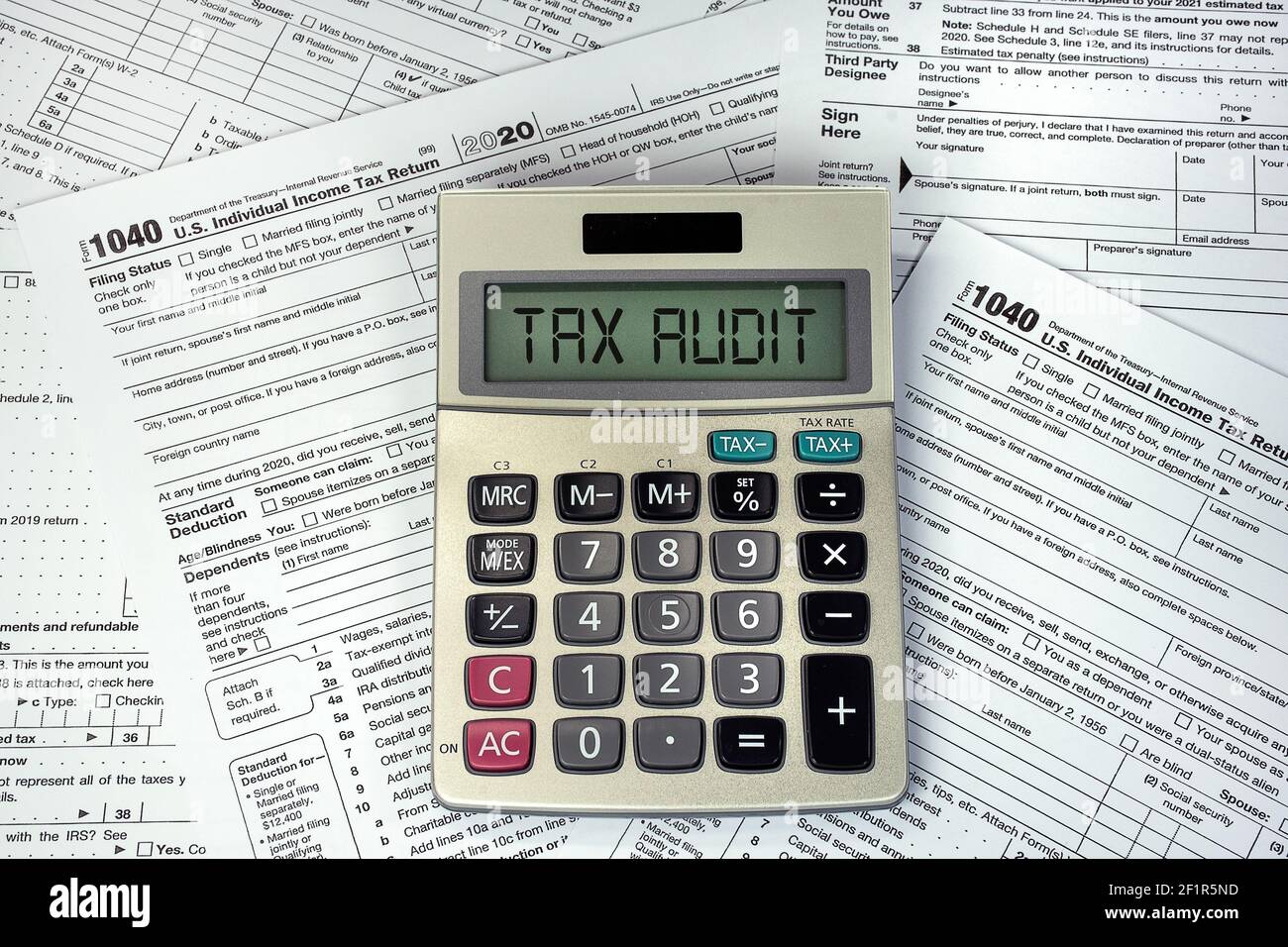 Tax audit text on business calculator screen with 1040 Internal Revenue Tax Forms Stock Photo