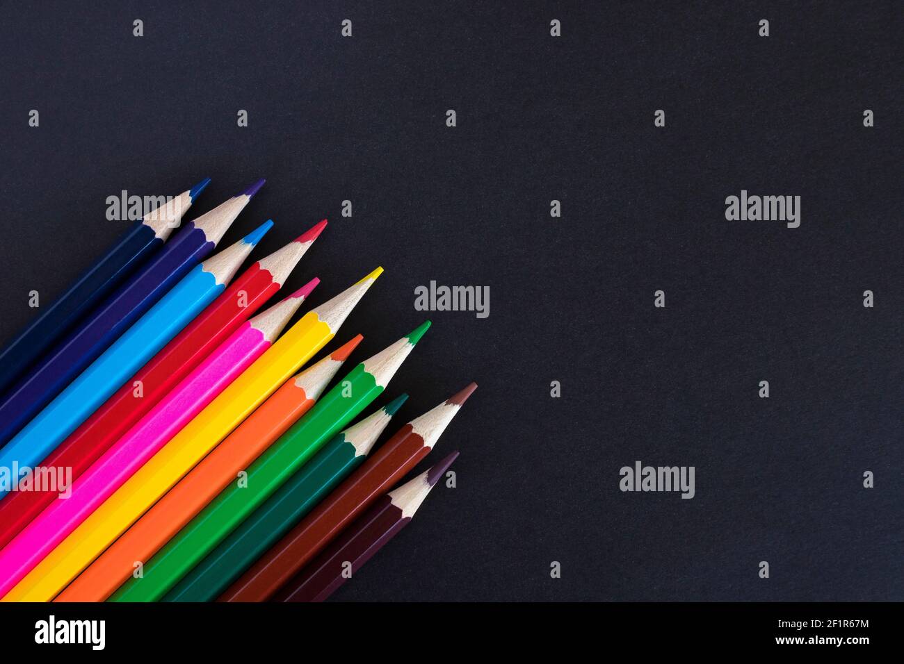 Colored pencils on a black background with copy space for text. Stock Photo