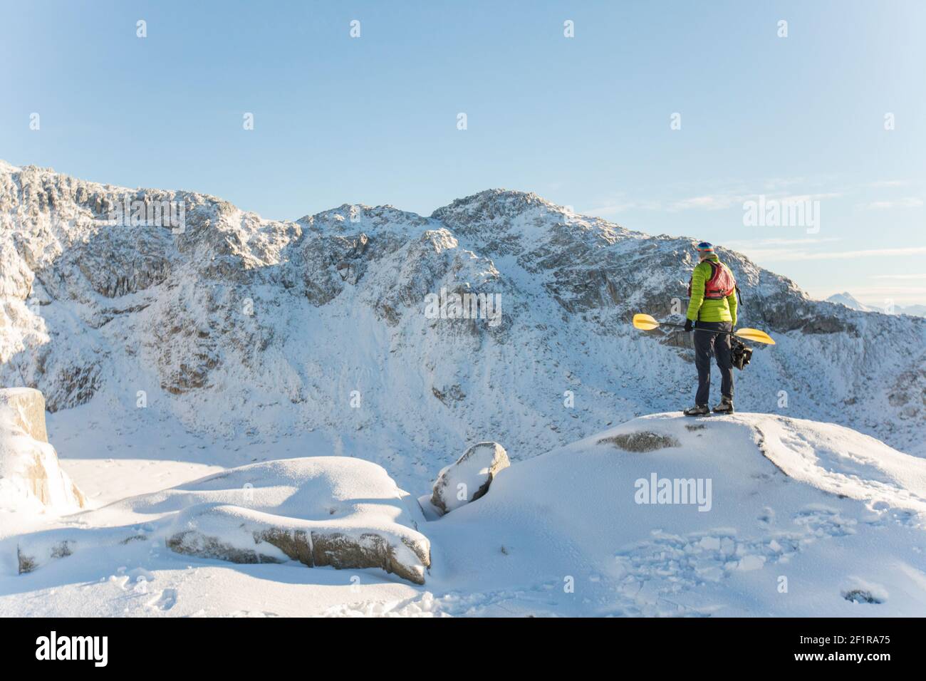 Paddler looks down on frozen lake with disappointment, Stock Photo