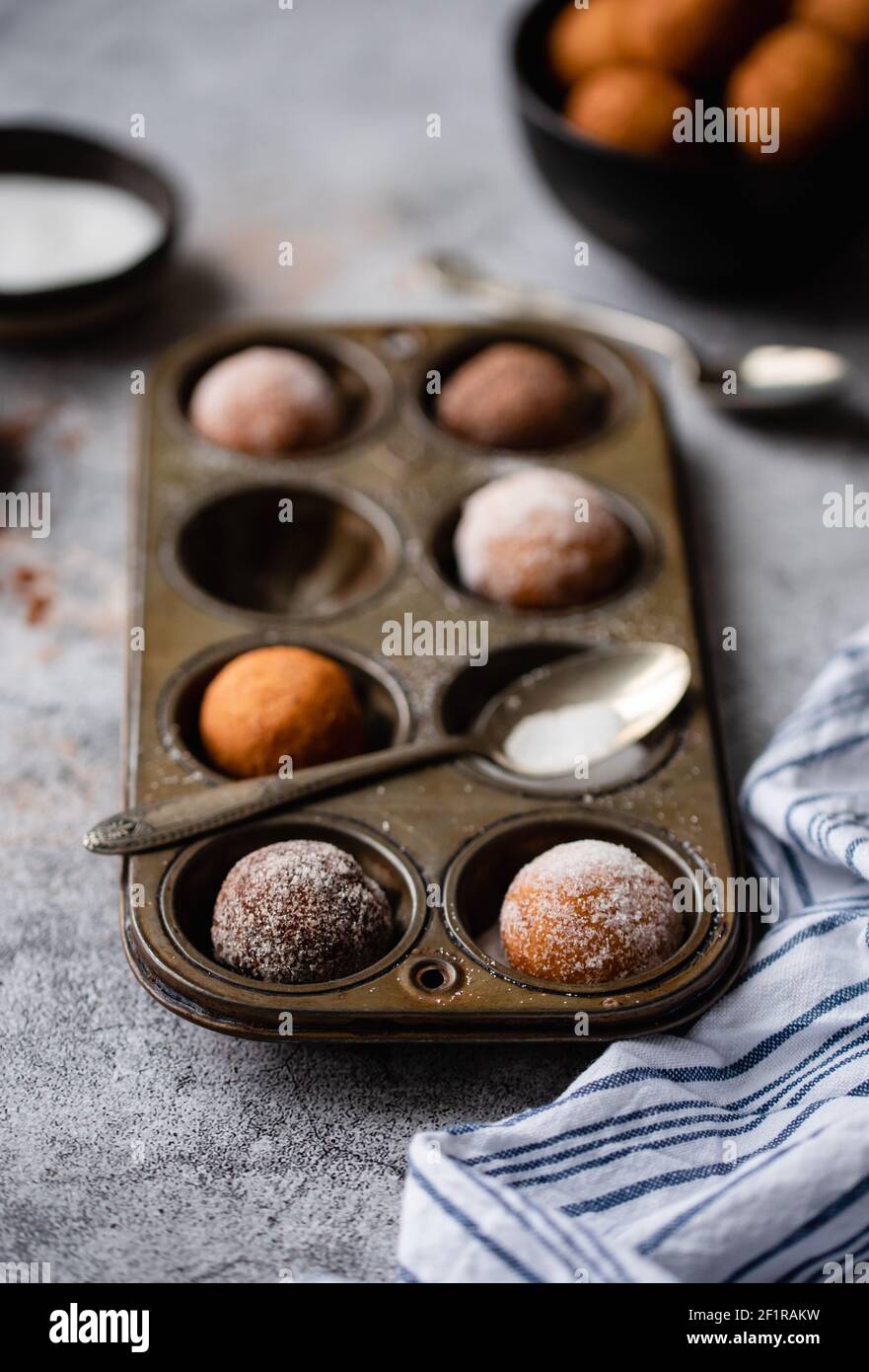 Close up of donut holes covered in sugar in a baking tin. Stock Photo