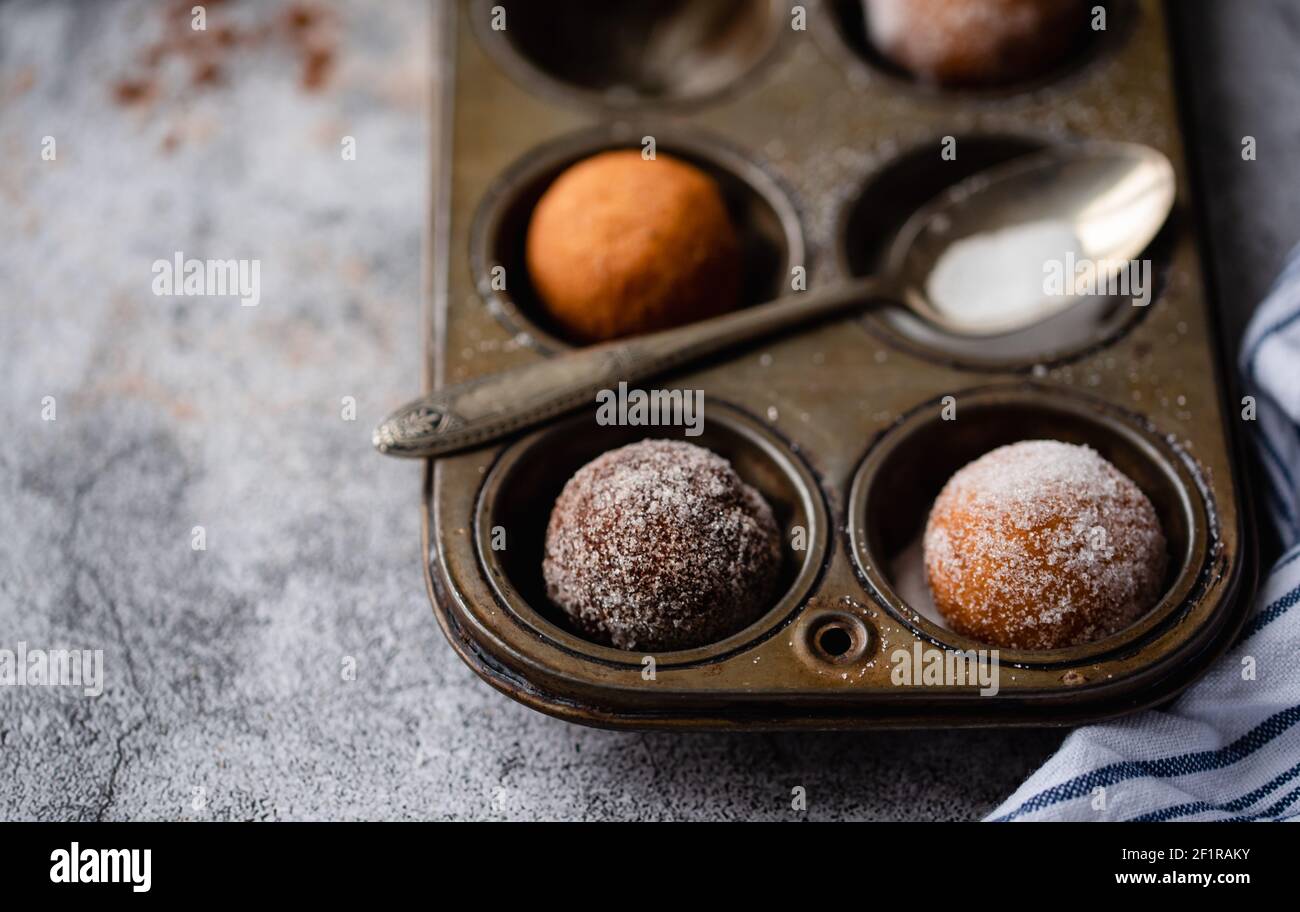 Close up of donut holes covered in sugar in a baking tin. Stock Photo