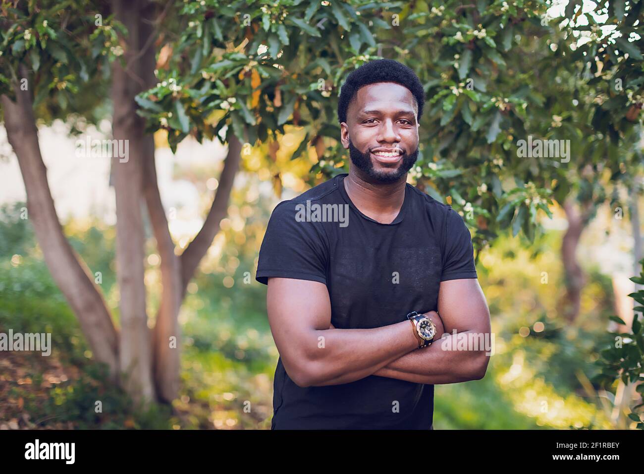 Headshot of a young black man with arms crossed Stock Photo Alamy