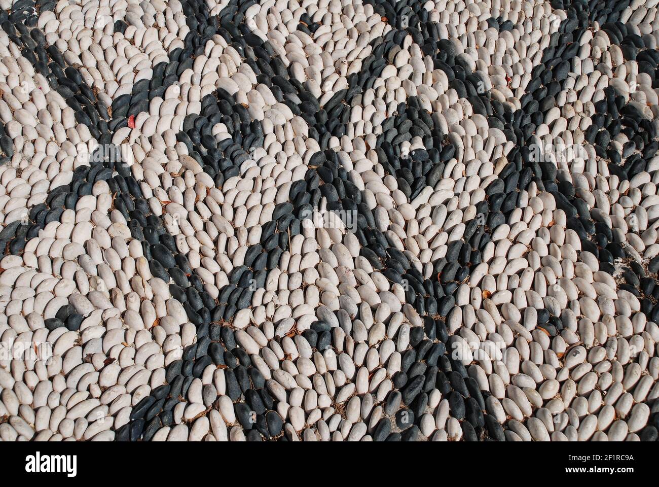 Mosaic sea pebble paving on the Greek island of Symi. Hoklakia mosaics are traditional to the Dodecanese islands. Stock Photo