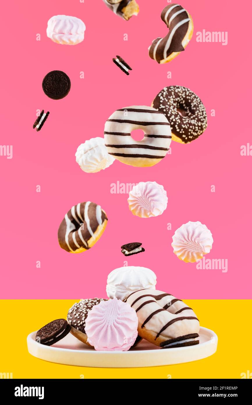Flying donuts and marshmallows on a pink background Stock Photo