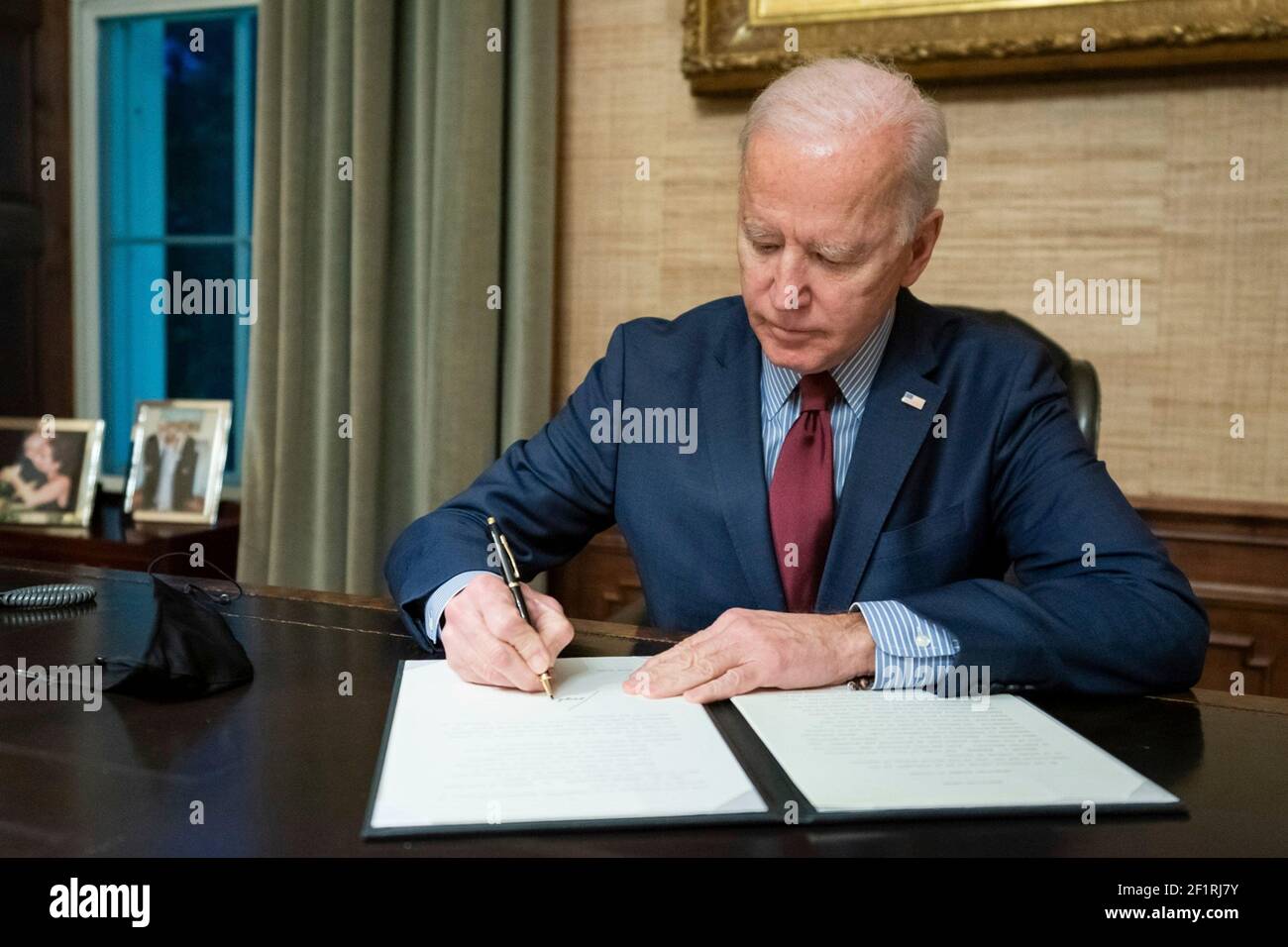 U.S President Joe Biden signs an executive order to promote voting access on the 56th anniversary of Bloody Sunday, from the Oval Office of the White House March 7, 2021 in Washington, D.C. Bloody Sunday, is the day that state troopers violently beat hundreds of civil rights marchers, on the Edmund Pettus Bridge in Selma, Alabama. Stock Photo