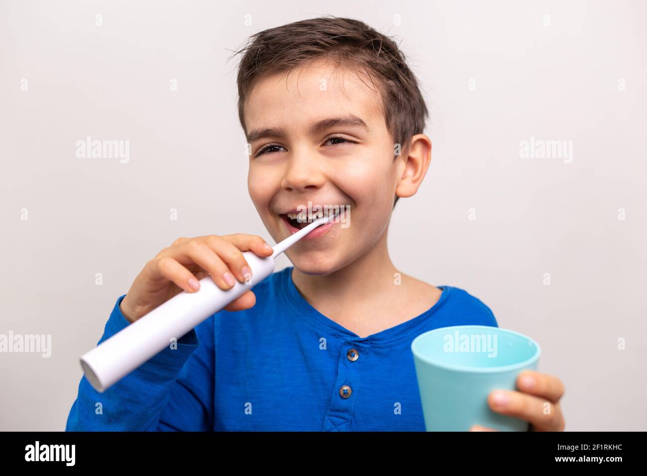six years old boy with Electric toothbrush on white background. Close