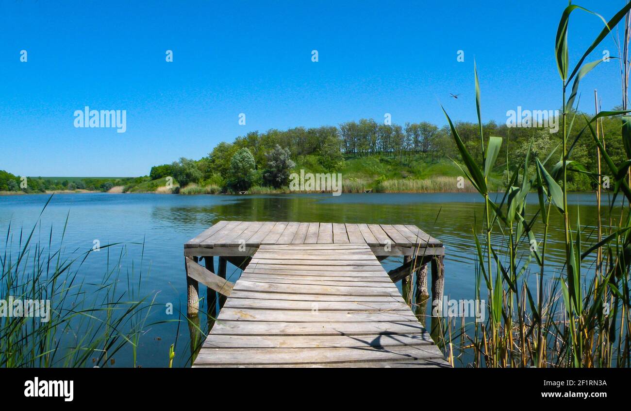 Long Old wooden pier and beautiful lake. Empty on small country