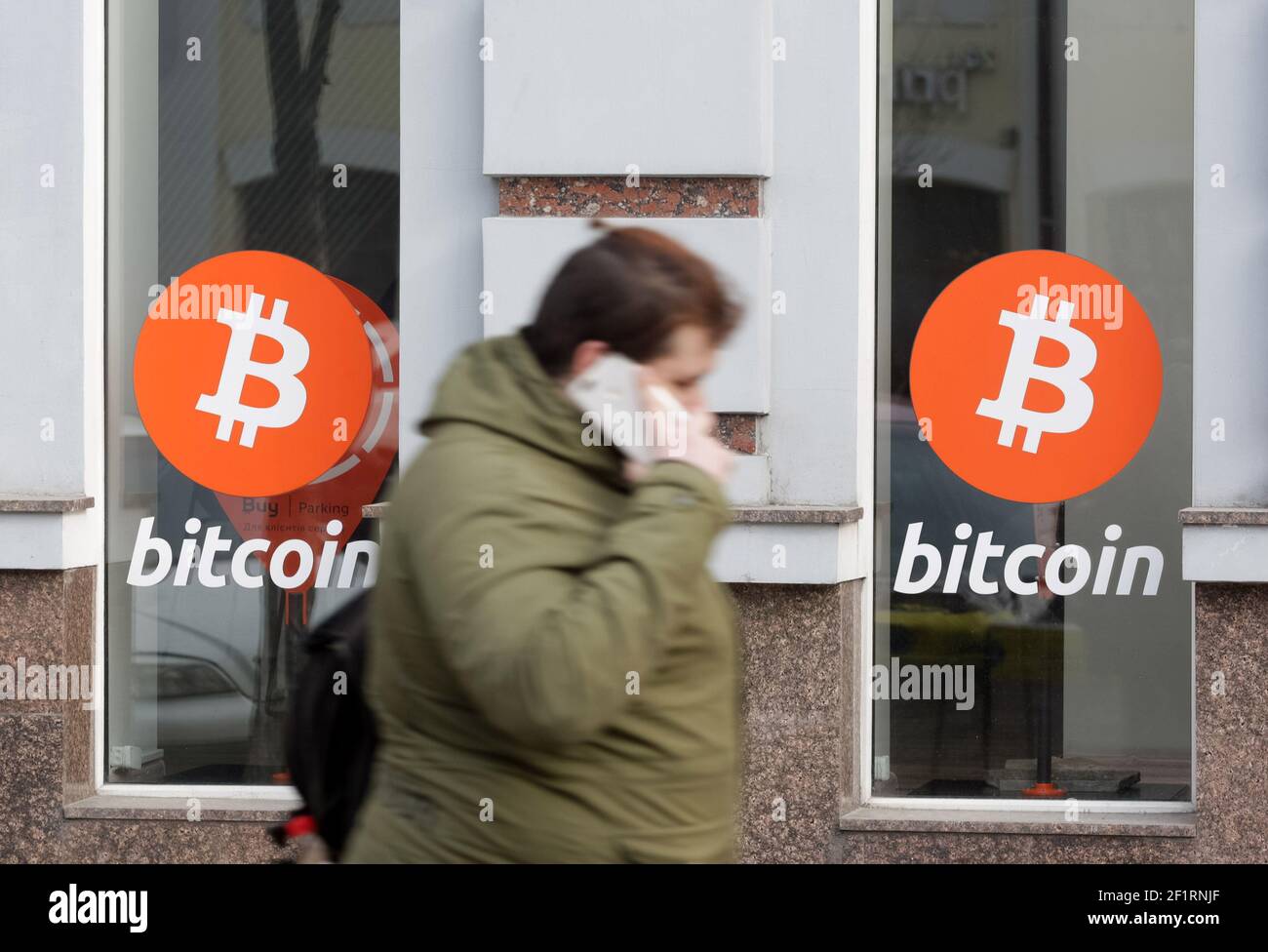 A woman walks past an office of Bitcoin (BTC) cryptocurrency exchange.Over  the past day, the price of Bitcoin cryptocurrency increased by 7.46% and  reached $ 54,310, Bitcoin quotes have recovered their growth,