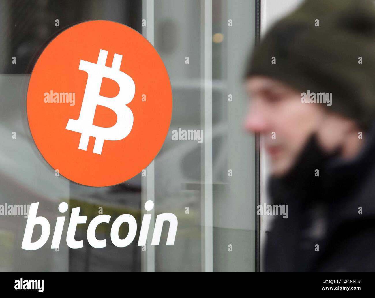 A man walks past an office of Bitcoin (BTC) cryptocurrency exchange.Over  the past day, the price of Bitcoin cryptocurrency increased by 7.46% and  reached $ 54,310, Bitcoin quotes have recovered their growth,