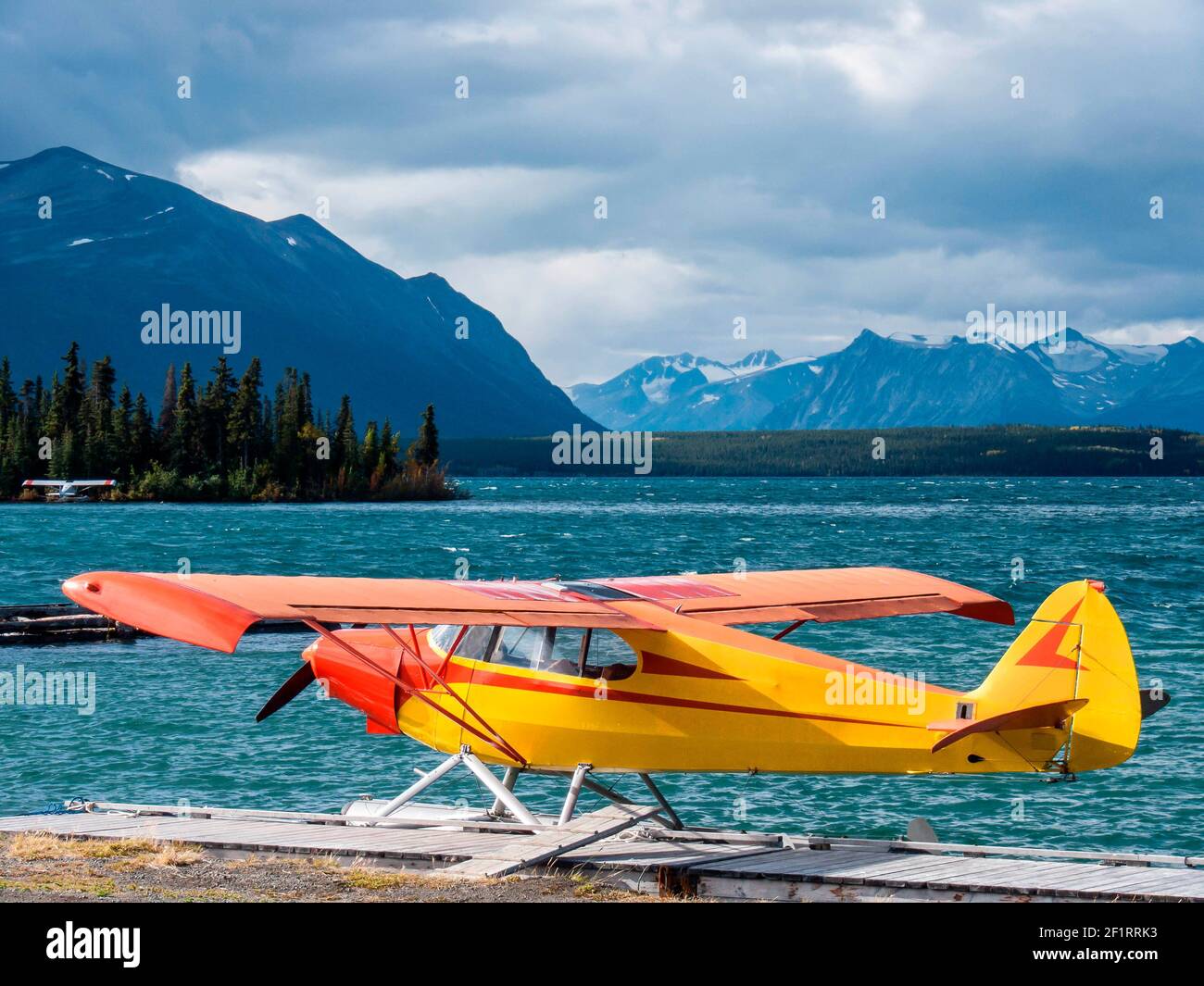 Small floatplane at a landing stage of a lake with mountains as background Stock Photo