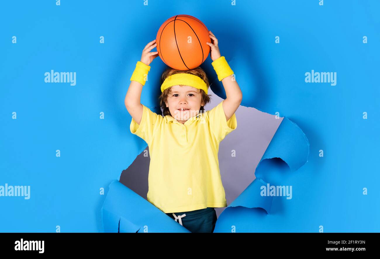 Little basketballer. Child in sportswear throws ball. Basketball training. Sports equipment. Kid sport activities. Stock Photo