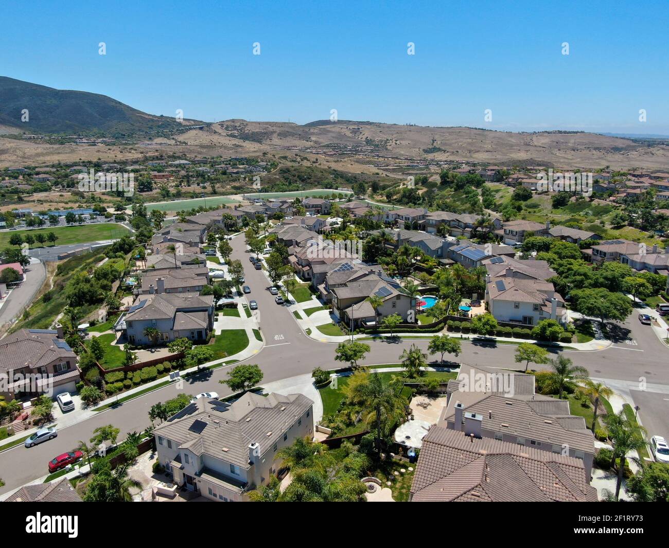 Aerial view of suburban neighborhood with big mansions with pool in San