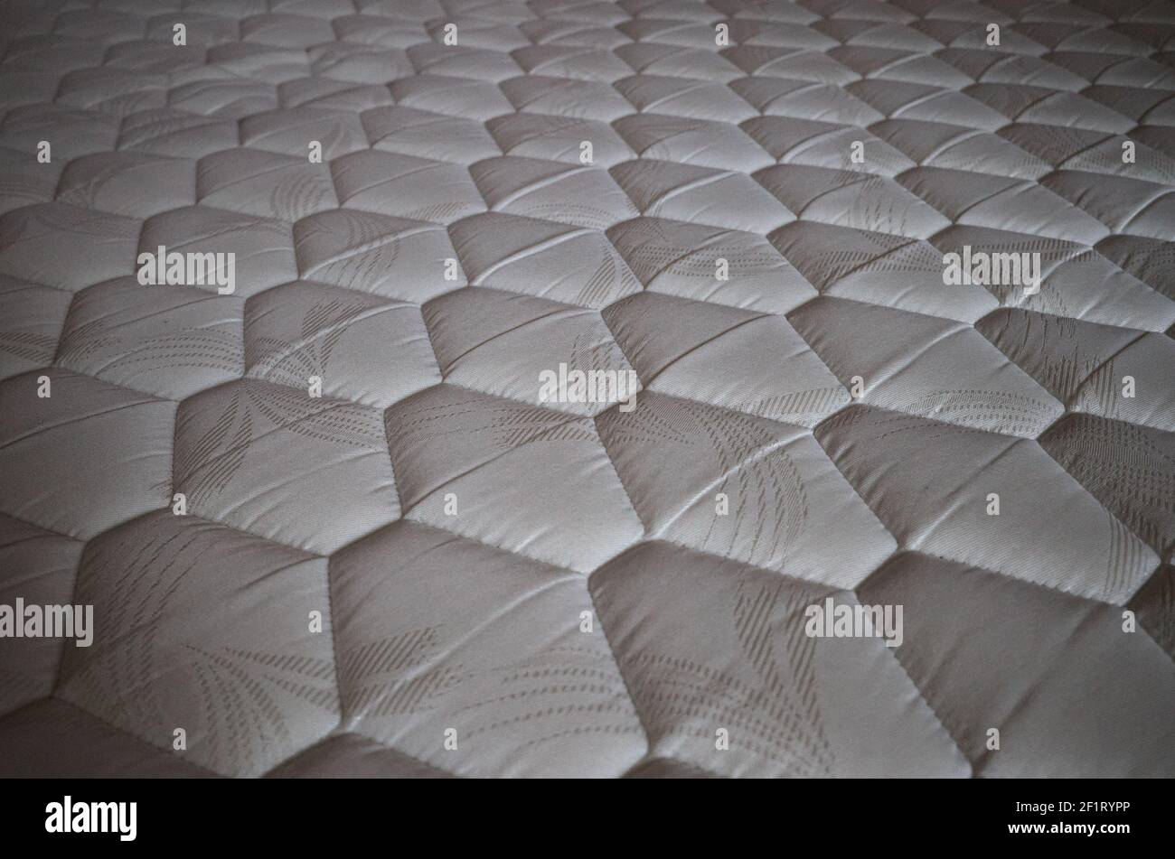 A diamond pattern on a orthopedic mattress close-up. Mattress fabric close up. Light color mattress with a rhombus pattern. Stock Photo