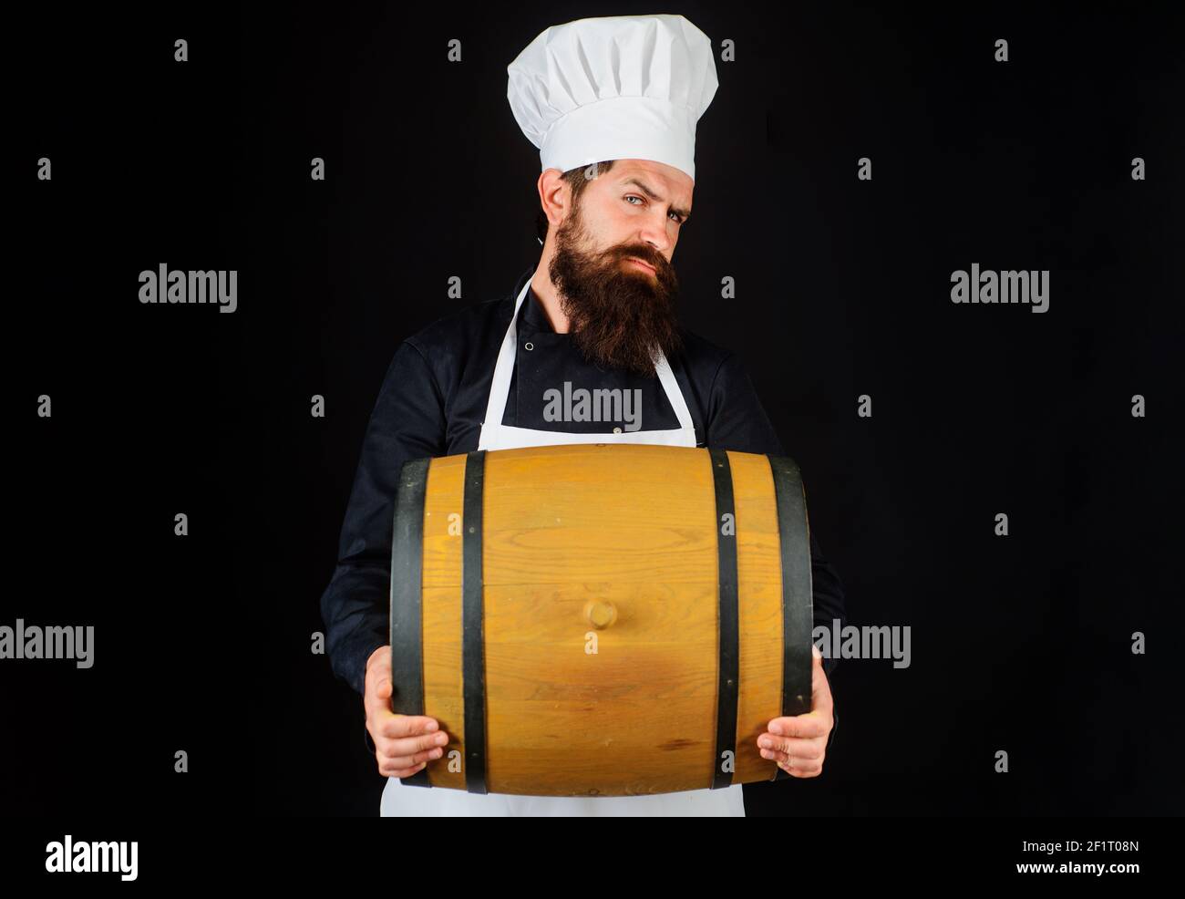 Bearded cook with wooden barrel. Homemade wine. Equipment for preparate of beer. Brewery for maturing alcohol. Celebration oktoberfest festival. Stock Photo