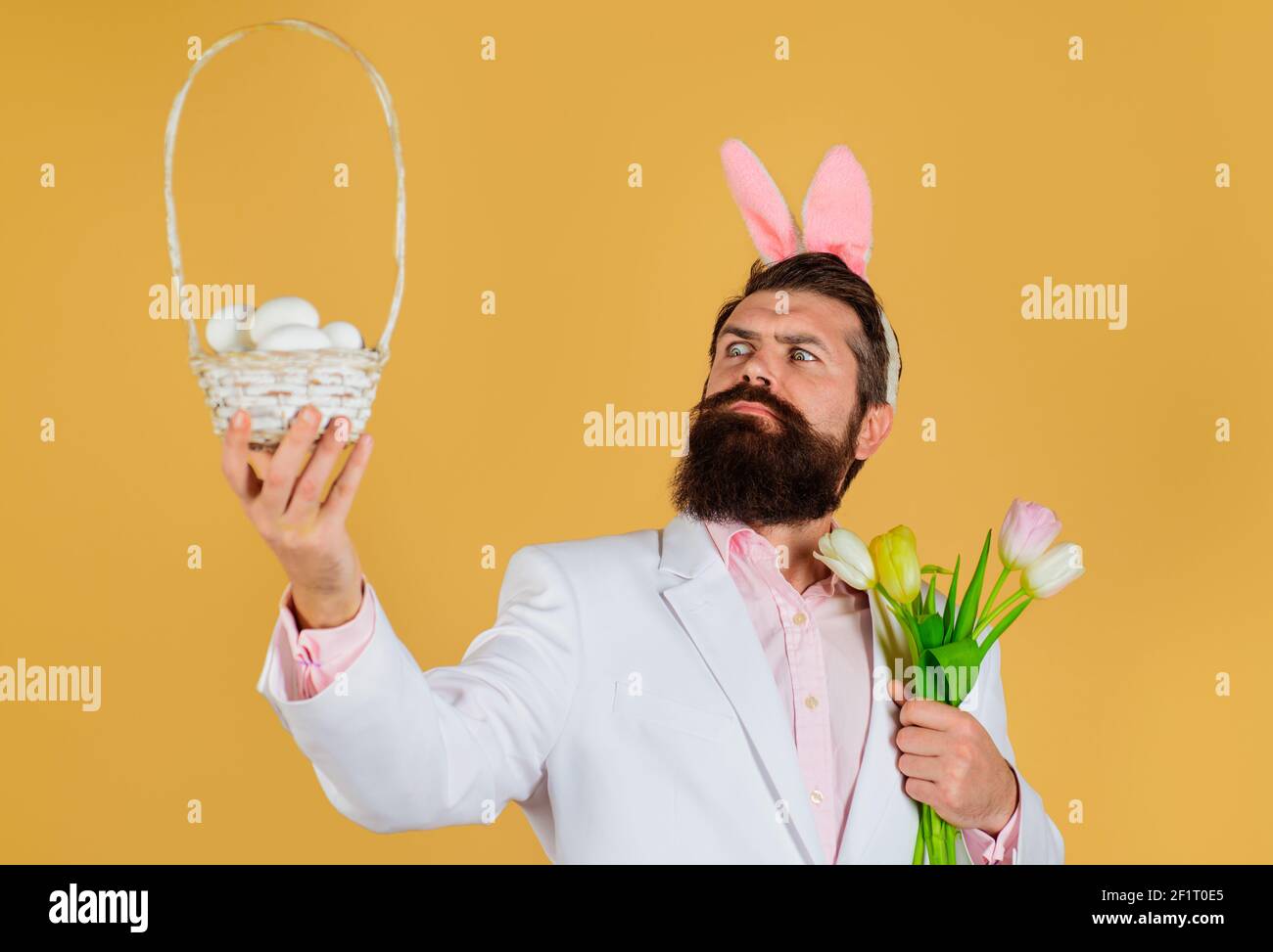 Happy Easter. Bearded male with basket eggs and Bouquet of spring ...