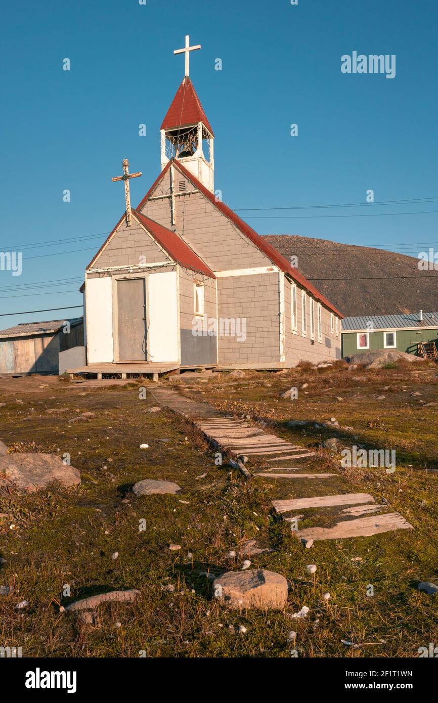 Small anglican church in the Canadian arctic in the golden hour.  St. Michael and All Angels Church in Inuit community of Qikiqtarjuaq, Broughton Isla Stock Photo