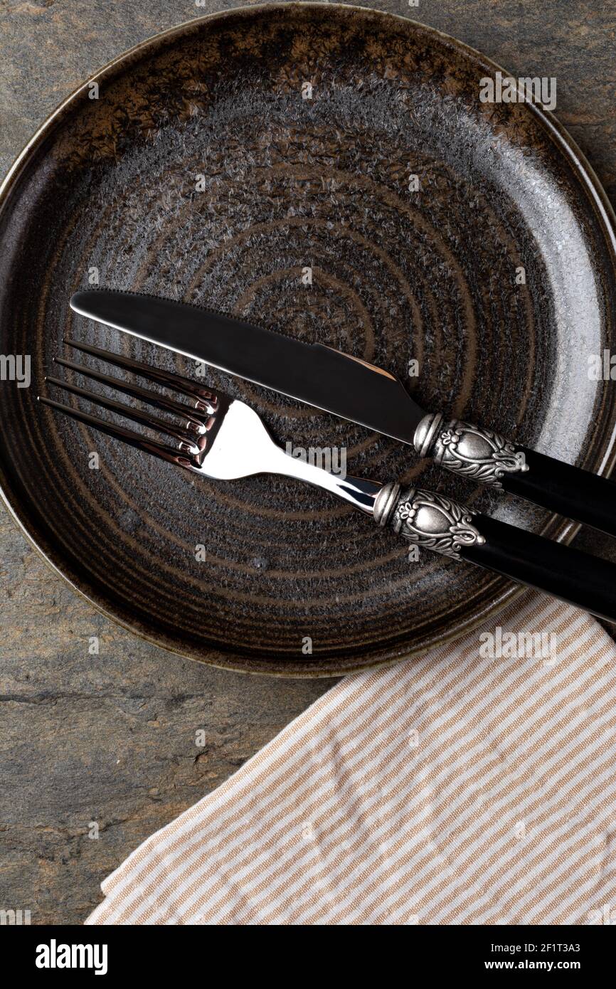 Plate, knife and fork on stone background Stock Photo