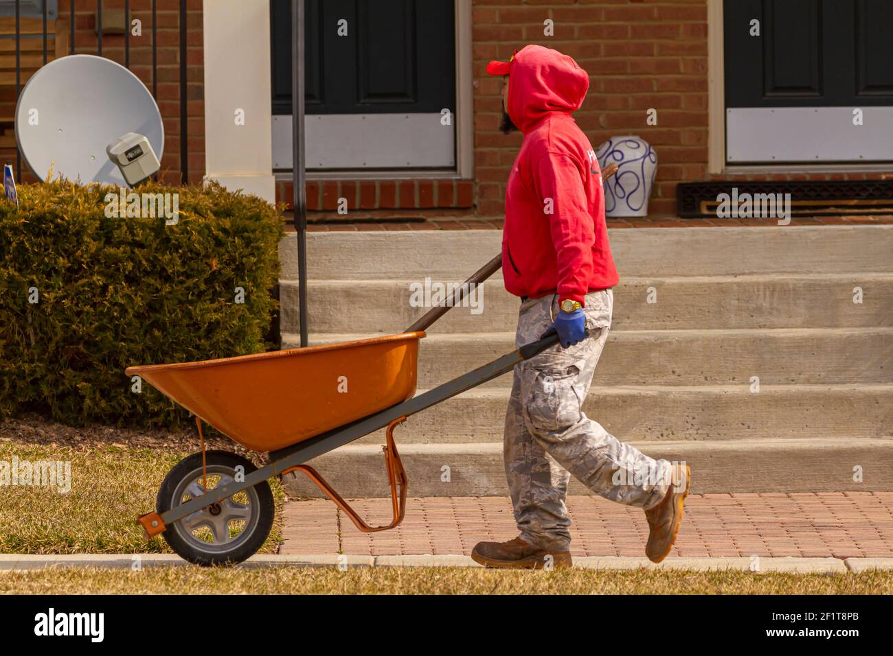 Clarksburg, MD, USA 03032021 A hispanic gardener is carrying an
