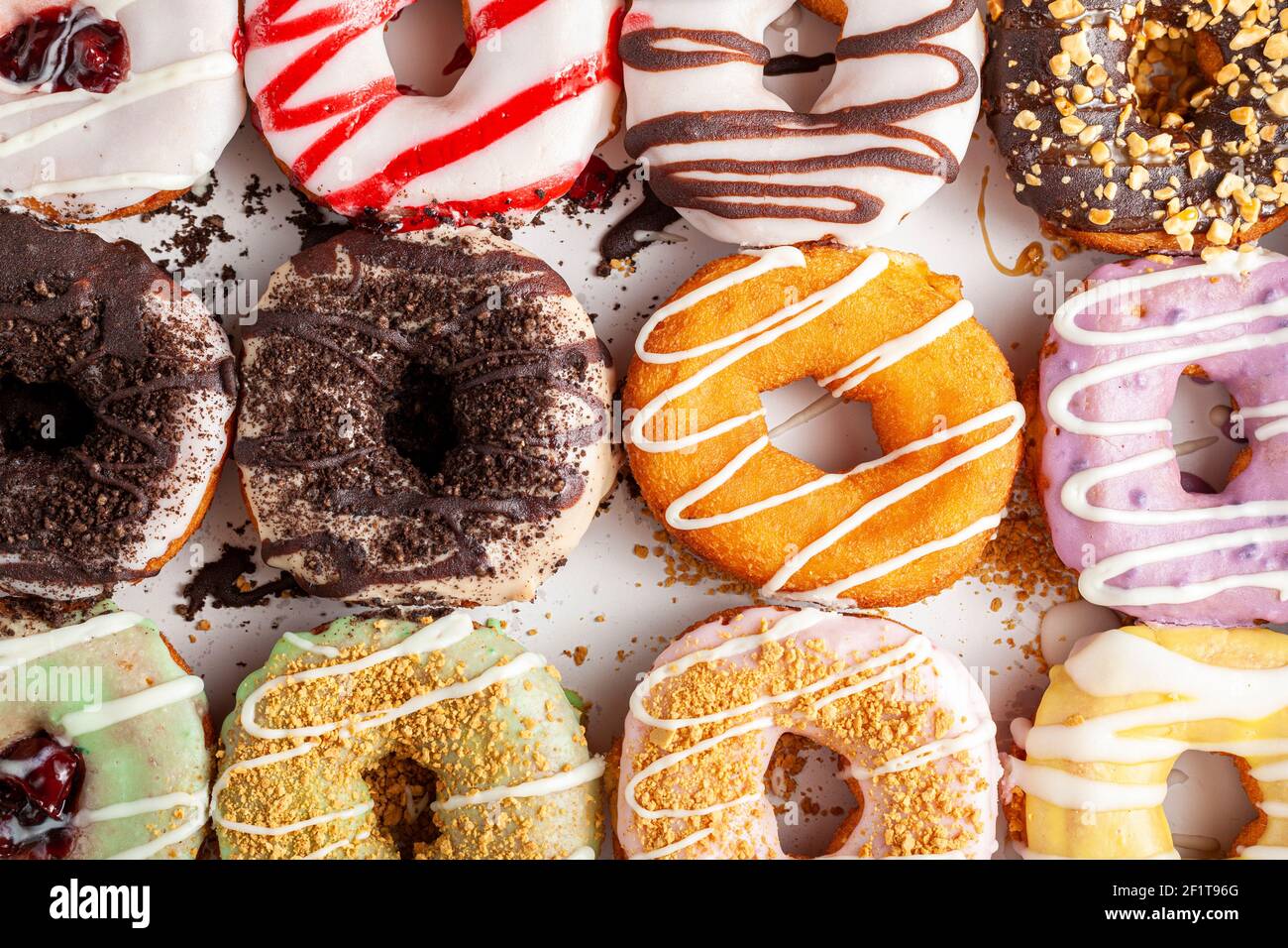 Flat lay top view image of a dozen donuts on card board box. A ...