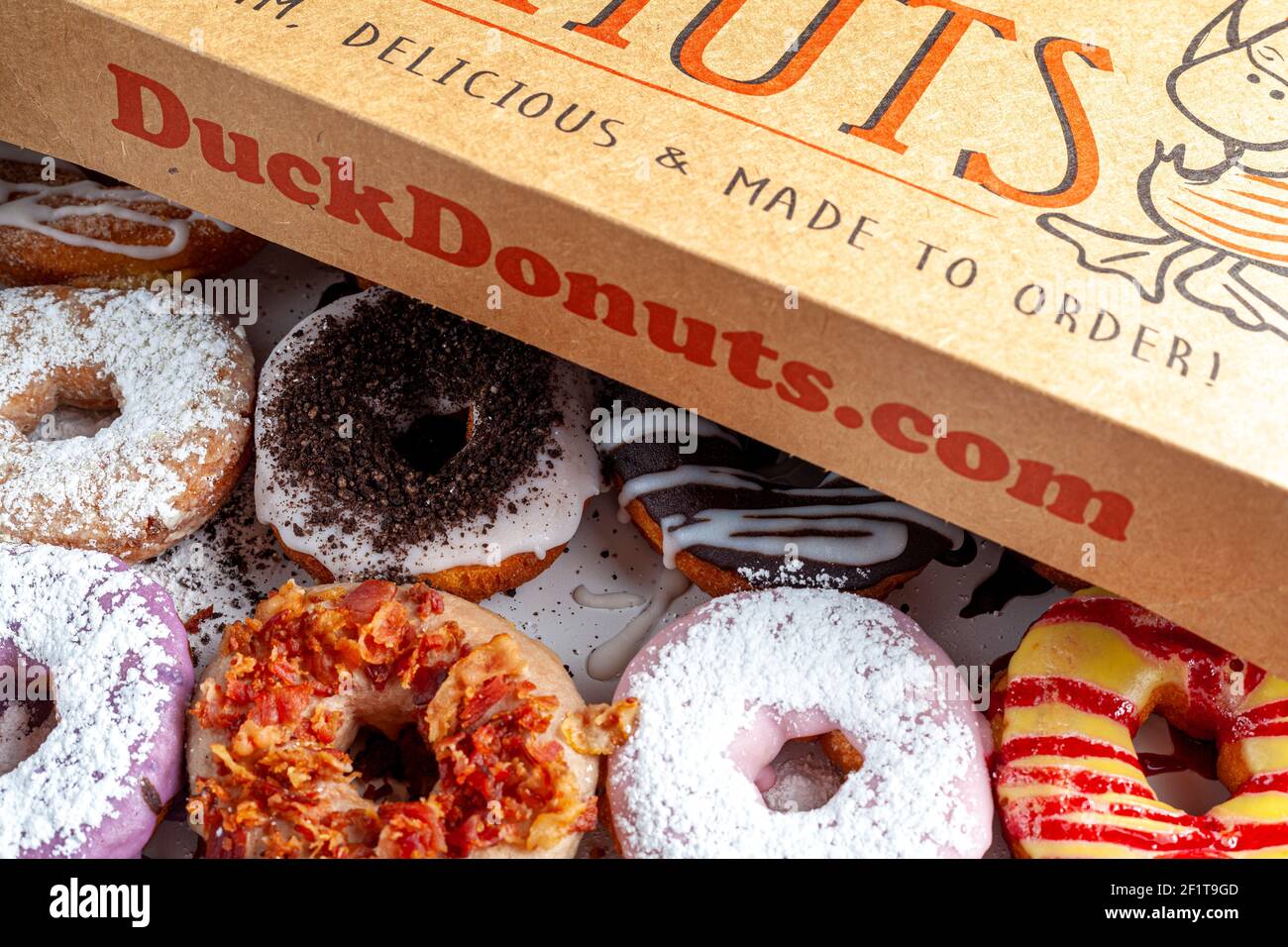 Clarksburg, MD, USA 03-04-2021: A cardboard box of a dozen donuts bought from the chain store Duck Donuts. A popular selection of assorted donuts are Stock Photo