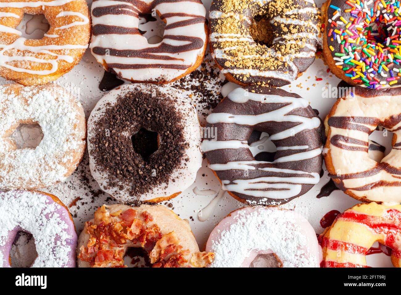 Flat lay top view image of a dozen donuts on card board box. A delicious assortment with different flavors and toppings. A vibrant colorful variety pa Stock Photo