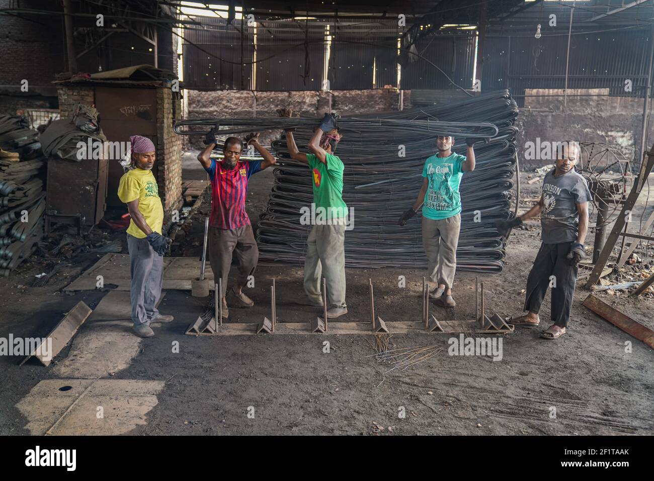 Rolling mill workerS seen working in the steel re-rolling mill without proper safety gear or tools in Dhaka, Bangladesh on March 9, 2021. Stock Photo