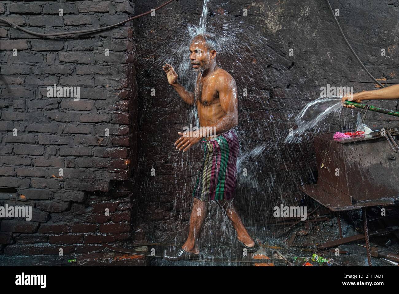 A rolling mill worker taking a bath at a rolling mill in Dhaka ...