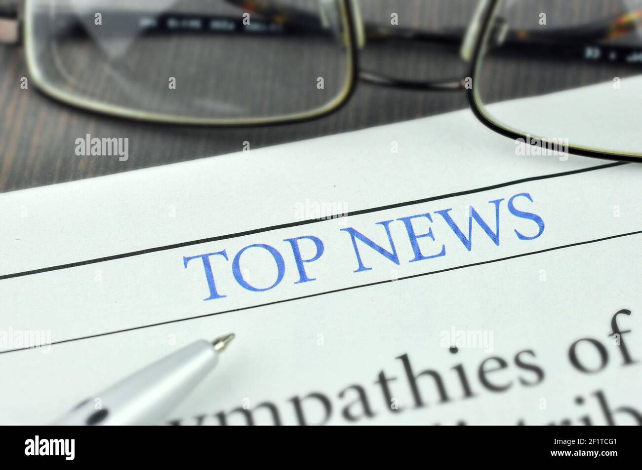 Pen, Eyeglasses and Newspaper. Heading a Top News in the Newspaper. Concept Top News. Macro photo. Stock Photo