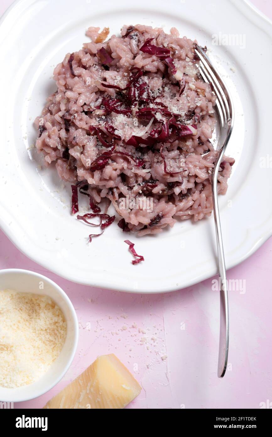 Italian risotto with red radicchio on a white plate. Venetian cuisine, Italy. View from above. Stock Photo