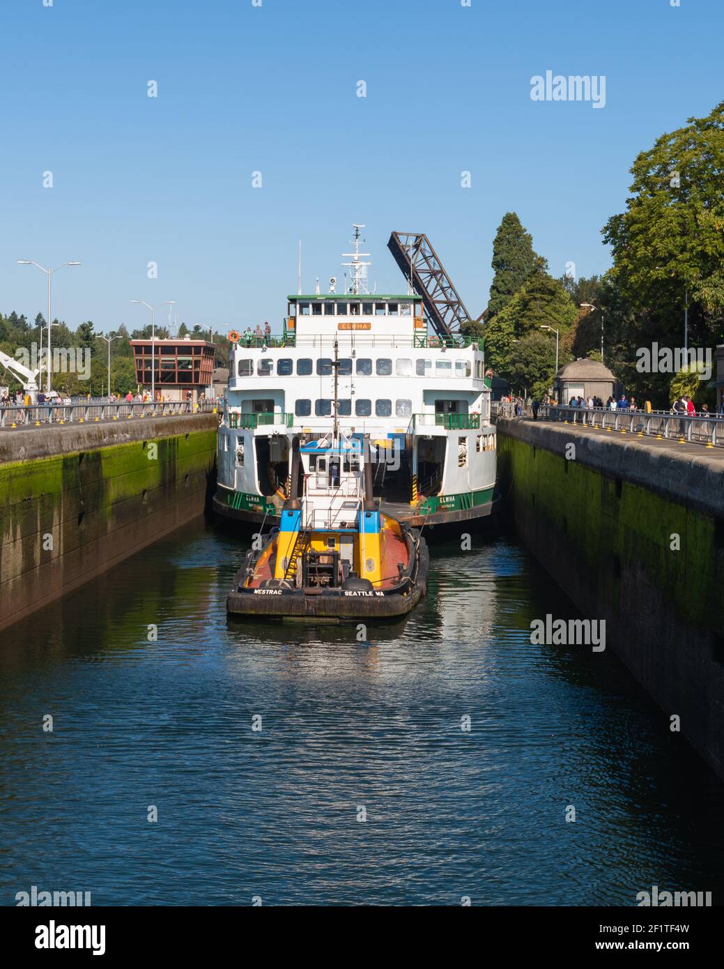 In preparation for maintenance the Washington State Ferry Elwha passes through the Ballard locks under tow of the tugboat Westrac Stock Photo