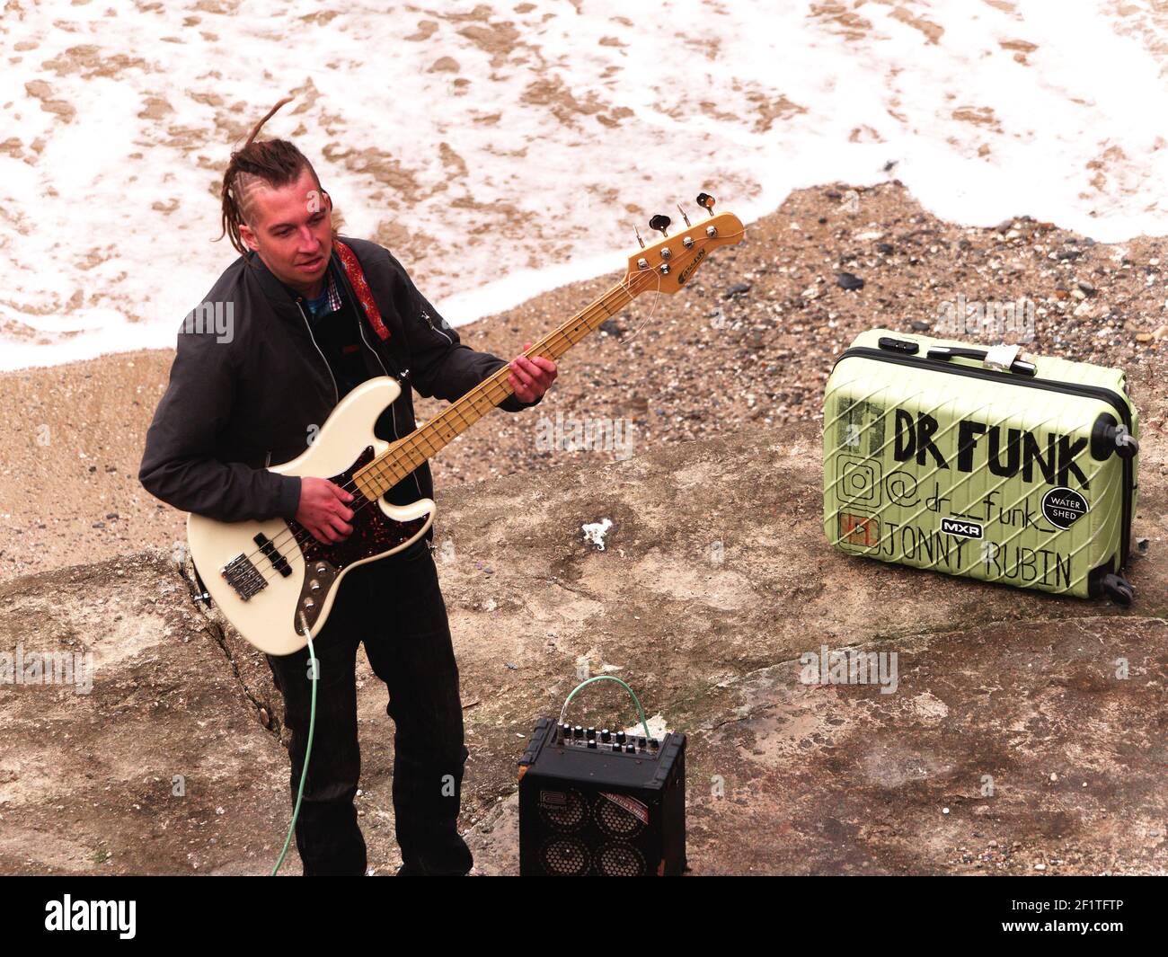Newquay,Cornwall, 09th March 2021. You Tube sensation Jonny Rubin known as Dr Funk with 10 million plus views. Started as a busker in Newquay, here recording his latest video at Towan beach, Jonny born in California and raised in Sunderland makes his home in Cornwall. His fame is based on funky blues based bass guitar playing.  Credit: Robert Taylor/Alamy Live News” Stock Photo
