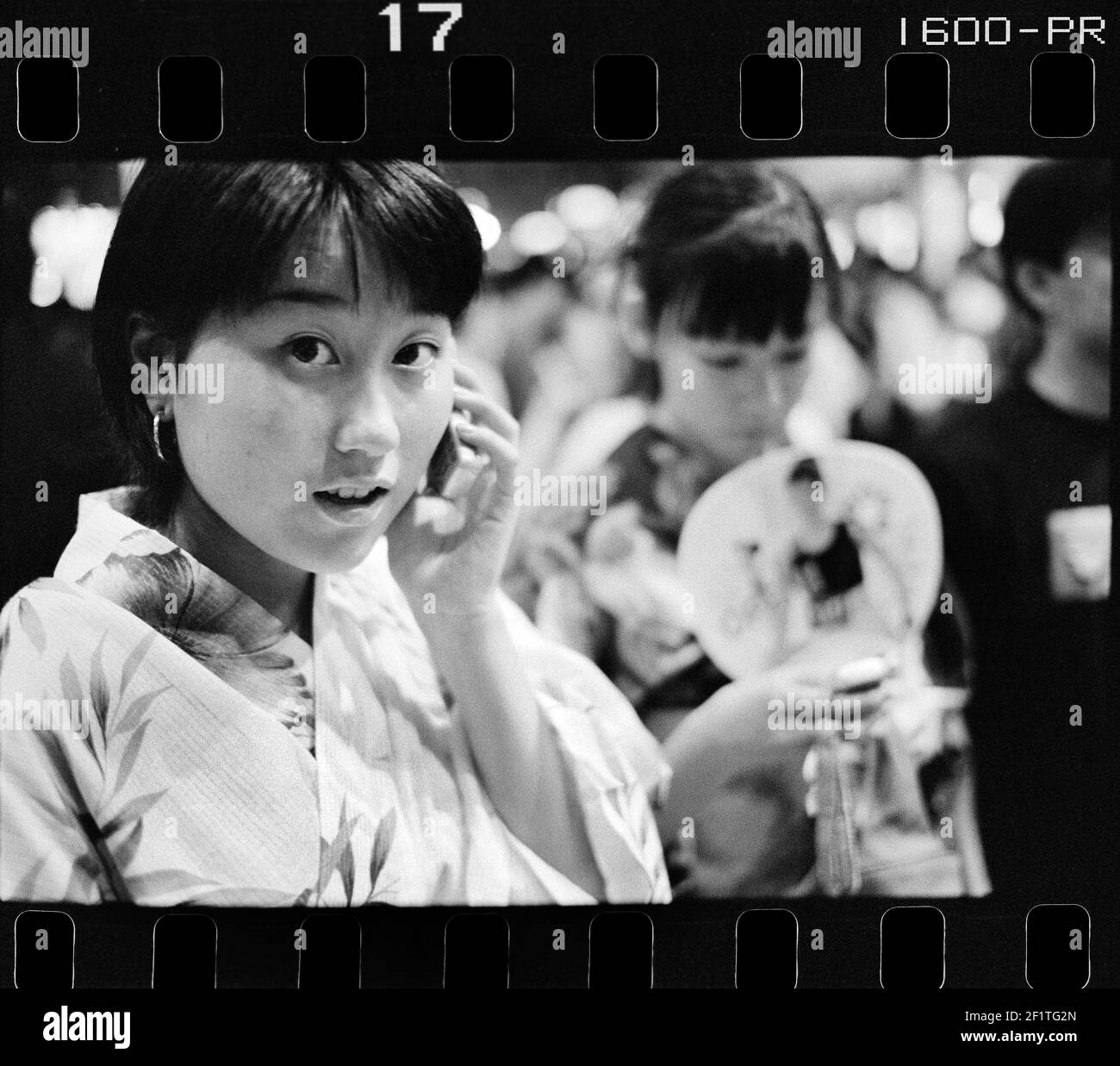 teenager wearing kimono talking on phone in the street Osaka ,Japan Stock Photo