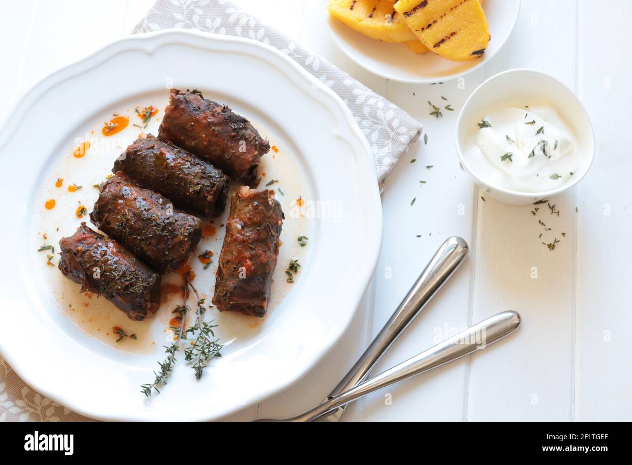 Romanian food. Stuffed Grape Leaves known as Sarmalute in foi de vita on white background. High angle view. Stock Photo