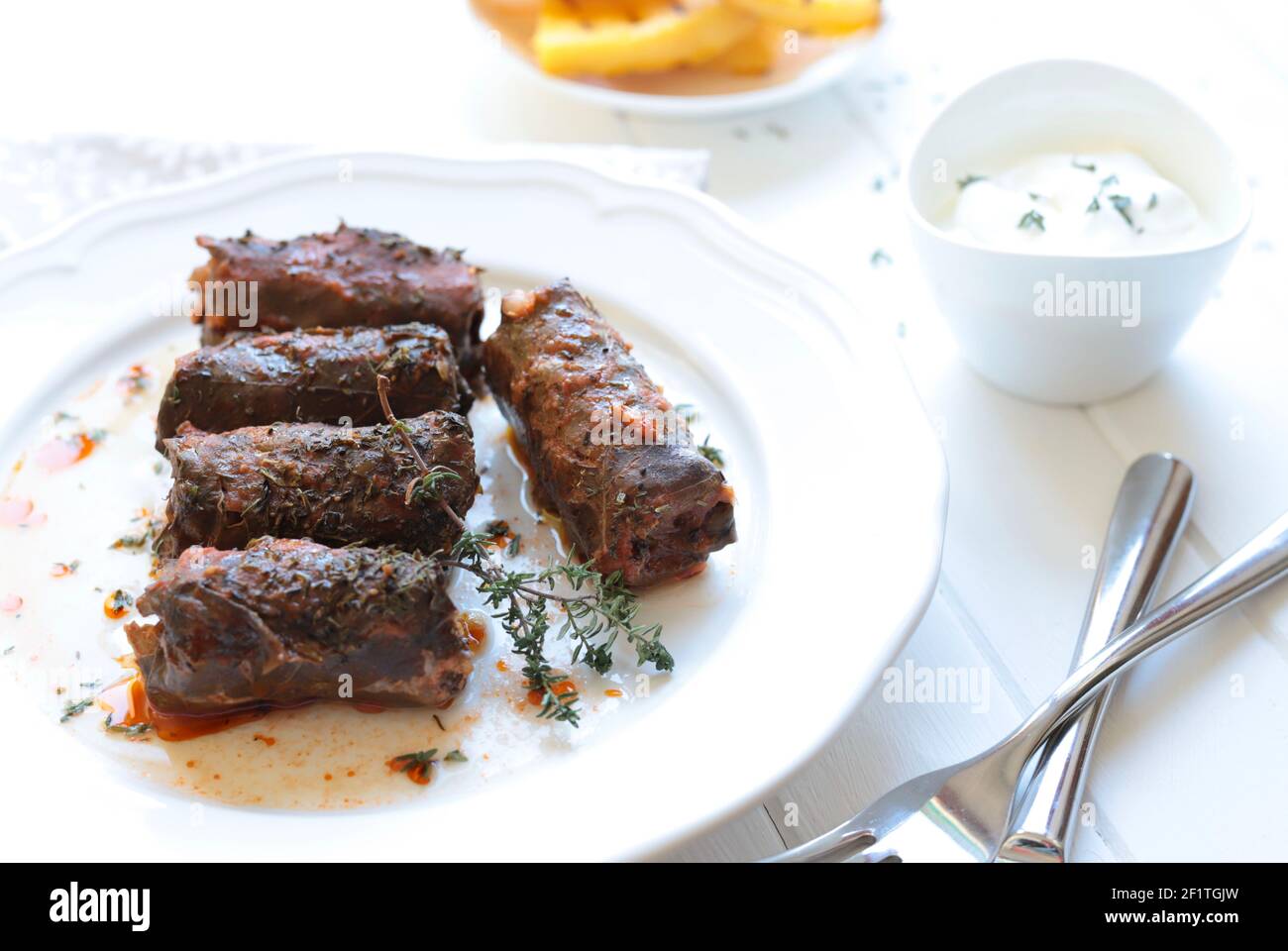 Romanian food. Stuffed Grape Leaves known as Sarmalute in foi de vita on white background. High angle view. Stock Photo