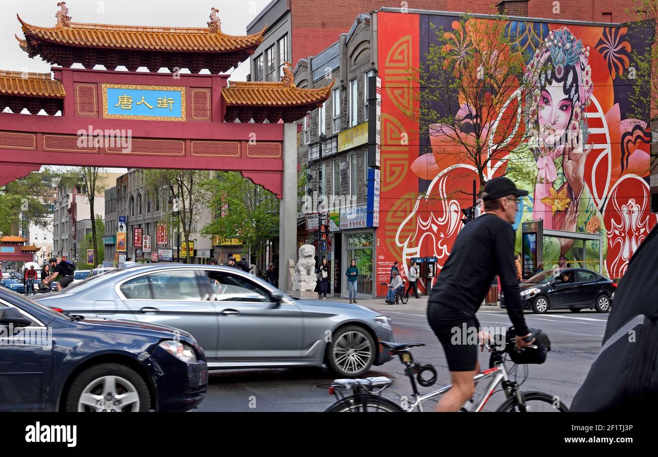 The Chinese arch gate, mural, people and traffic at the entrance of China town on st Laurent street in Montreal, Town, Canada, Canadian, Province, Quebec. Stock Photo
