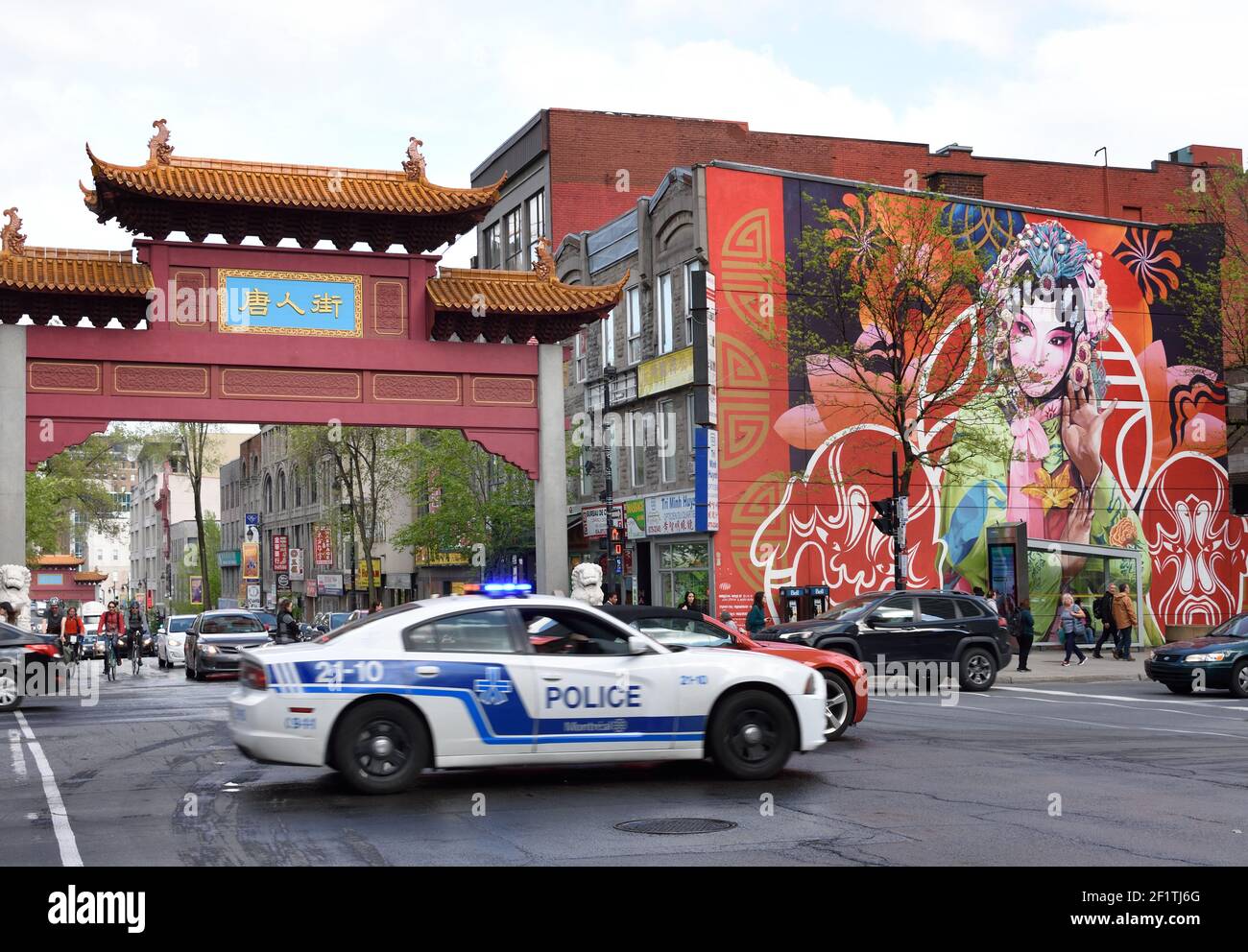 The Chinese arch gate, mural, people and traffic at the entrance of China town on st Laurent street in Montreal, Town, Canada, Canadian, Province, Quebec. Stock Photo
