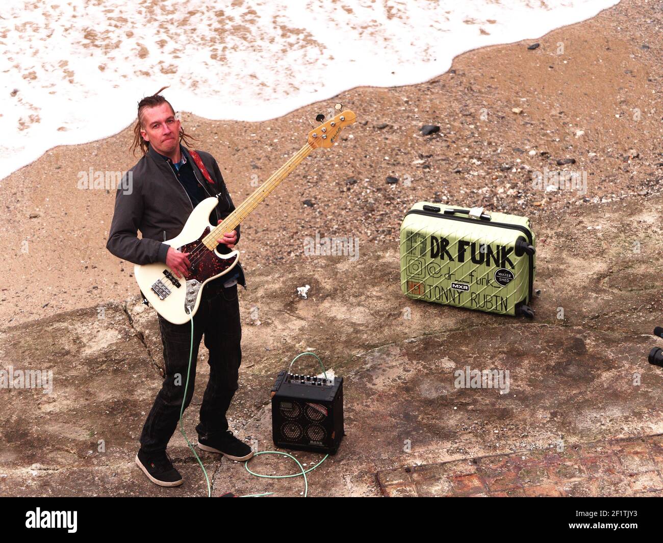 Newquay,Cornwall, 09th March 2021. You Tube sensation Jonny Rubin known as Dr Funk with 10 million plus views. Started as a busker in Newquay, here recording his latest video at Towan beach, Jonny born in California and raised in Sunderland makes his home in Cornwall. His fame is based on funky blues based bass guitar playing.  Credit: Robert Taylor/Alamy Live News” Stock Photo
