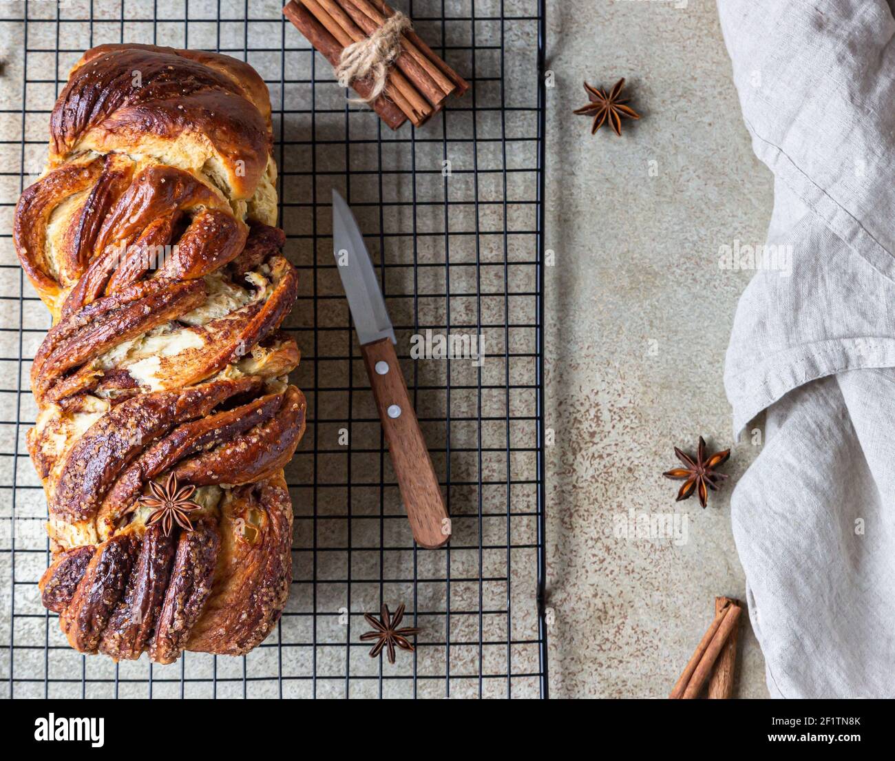 Cinnamon babka or swirl brioche bread on black metal grille. Cinnamon