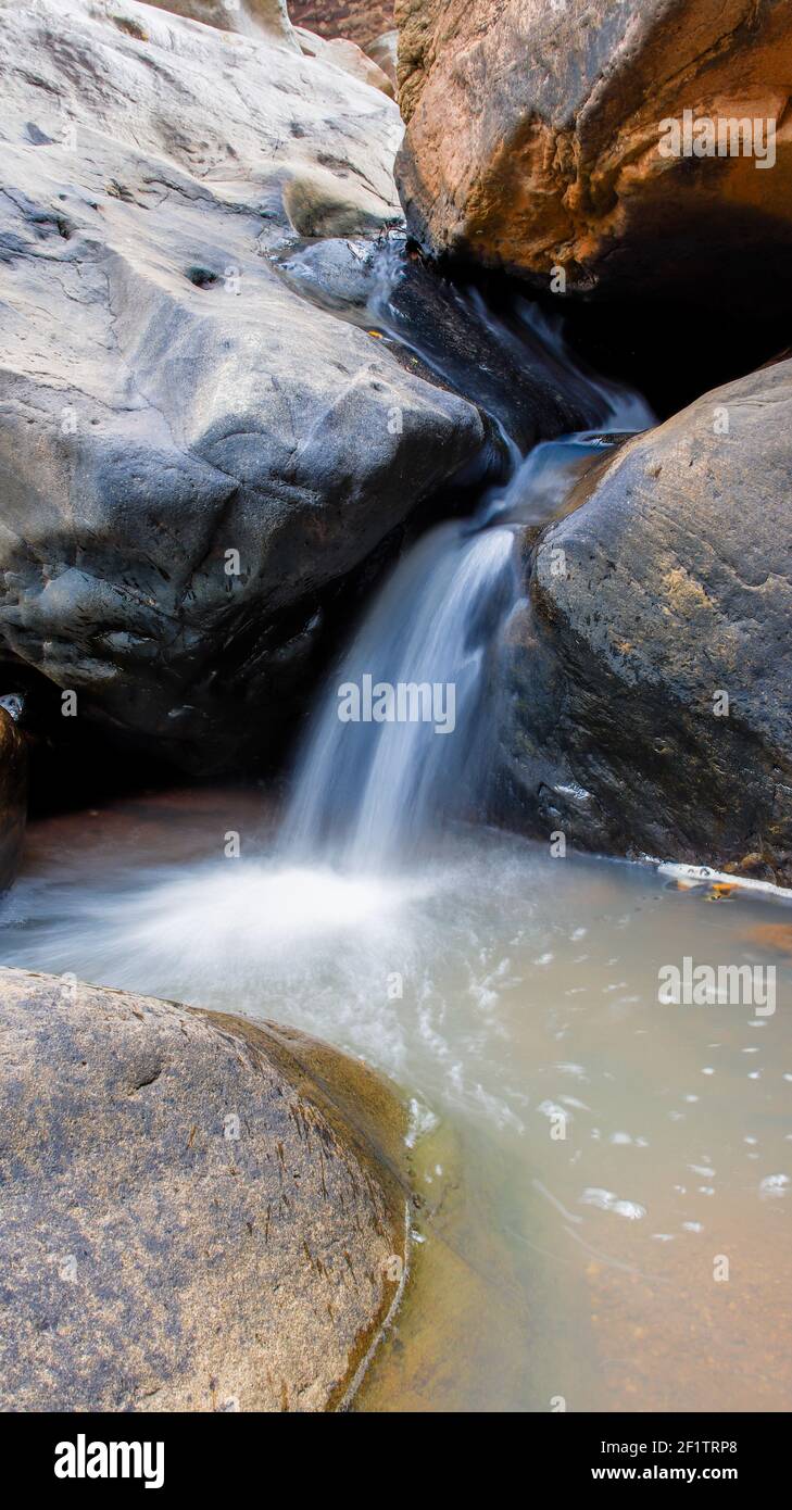 A vertical shot of a waterfall stream in between the rocks Stock Photo ...